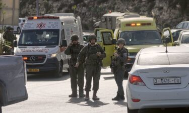 Israeli soldiers and emergency personnel gather near the scene of a shooting attack at a junction near Hebron in the occupied West Bank