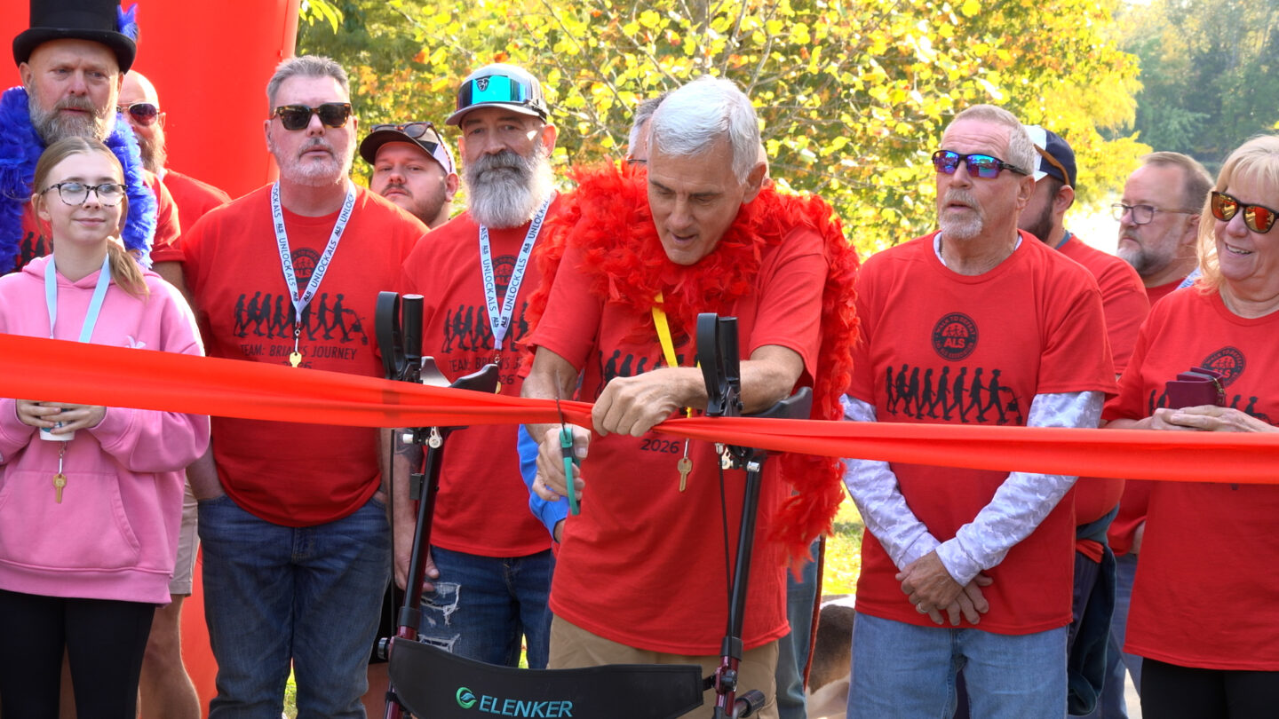 A man battling ALS cuts a ribbon to start a fundraising walk for the ALS Association. 